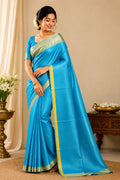 Sky blue silk saree with light green and gold border, draped with pallu