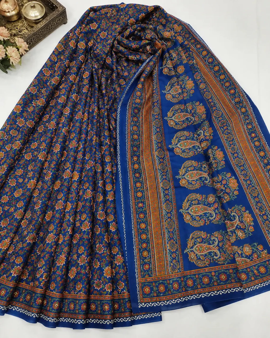 Teal floral saree drape with patterned pallu featuring circular motifs