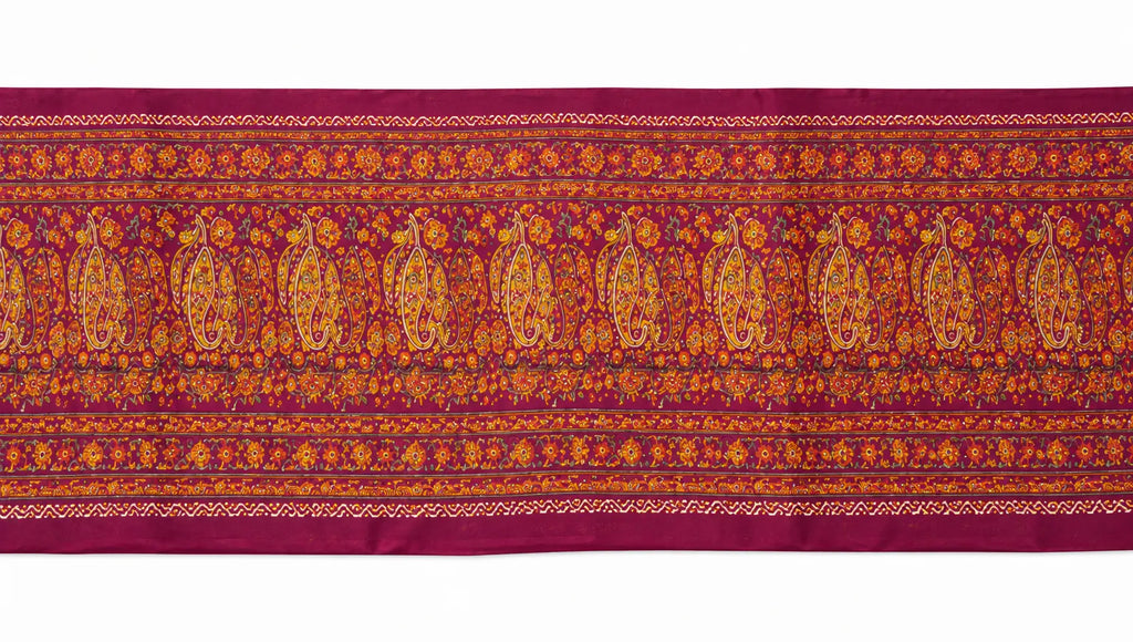 Saree fabric close-up with maroon and gold-toned paisley and border stripes